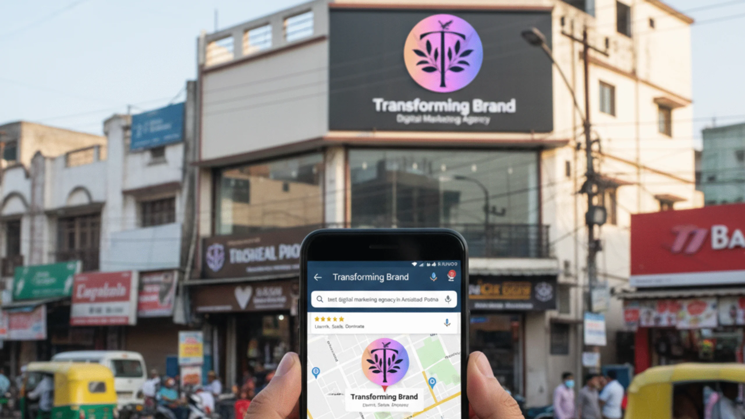 A hand holds a smartphone displaying a Google Maps search for "best digital marketing agency in Patna," highlighting the location of the "Transforming Brand" agency in a busy Patna street market.